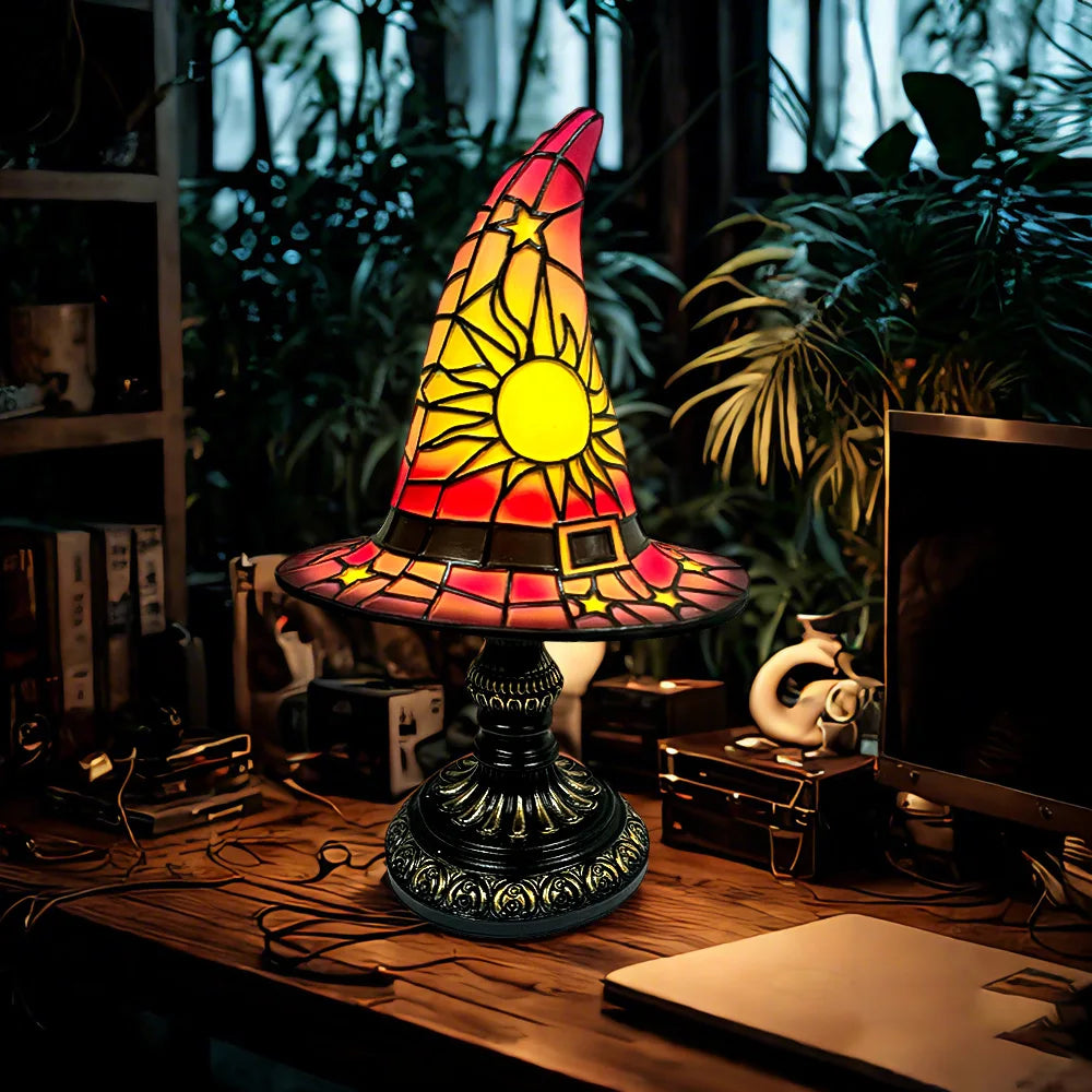 Vibrant red and yellow stained glass witch hat lamp glowing in a magical workspace