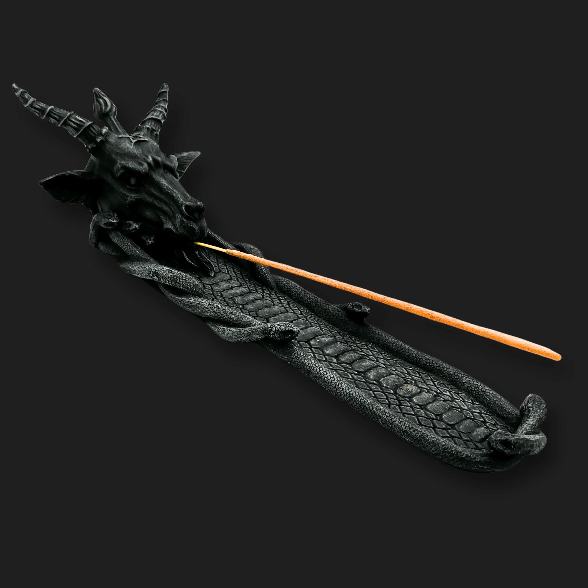 Baphomet incense burner holding lit incense stick on serpent tray