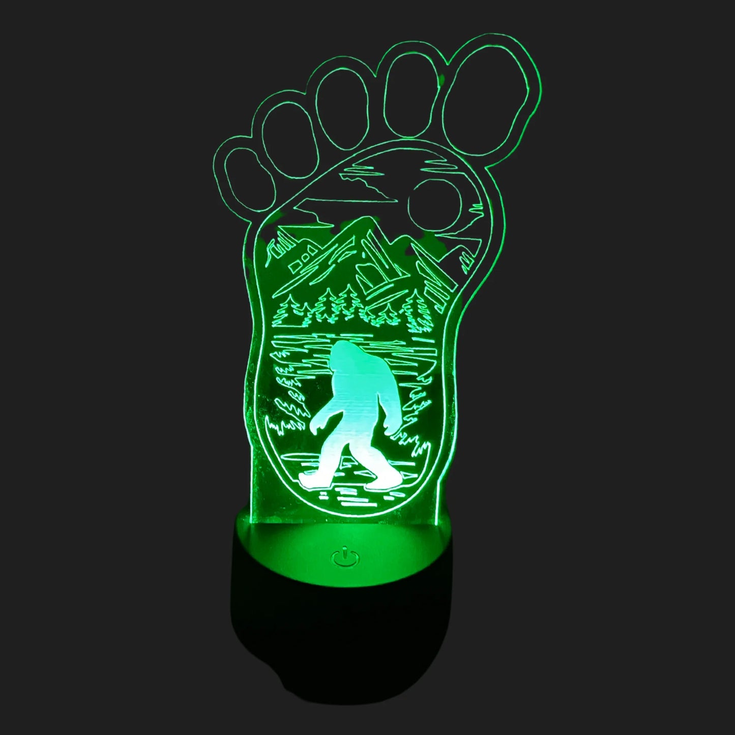 Bigfoot footprint LED lamp glowing green with mountain forest and Sasquatch silhouette.