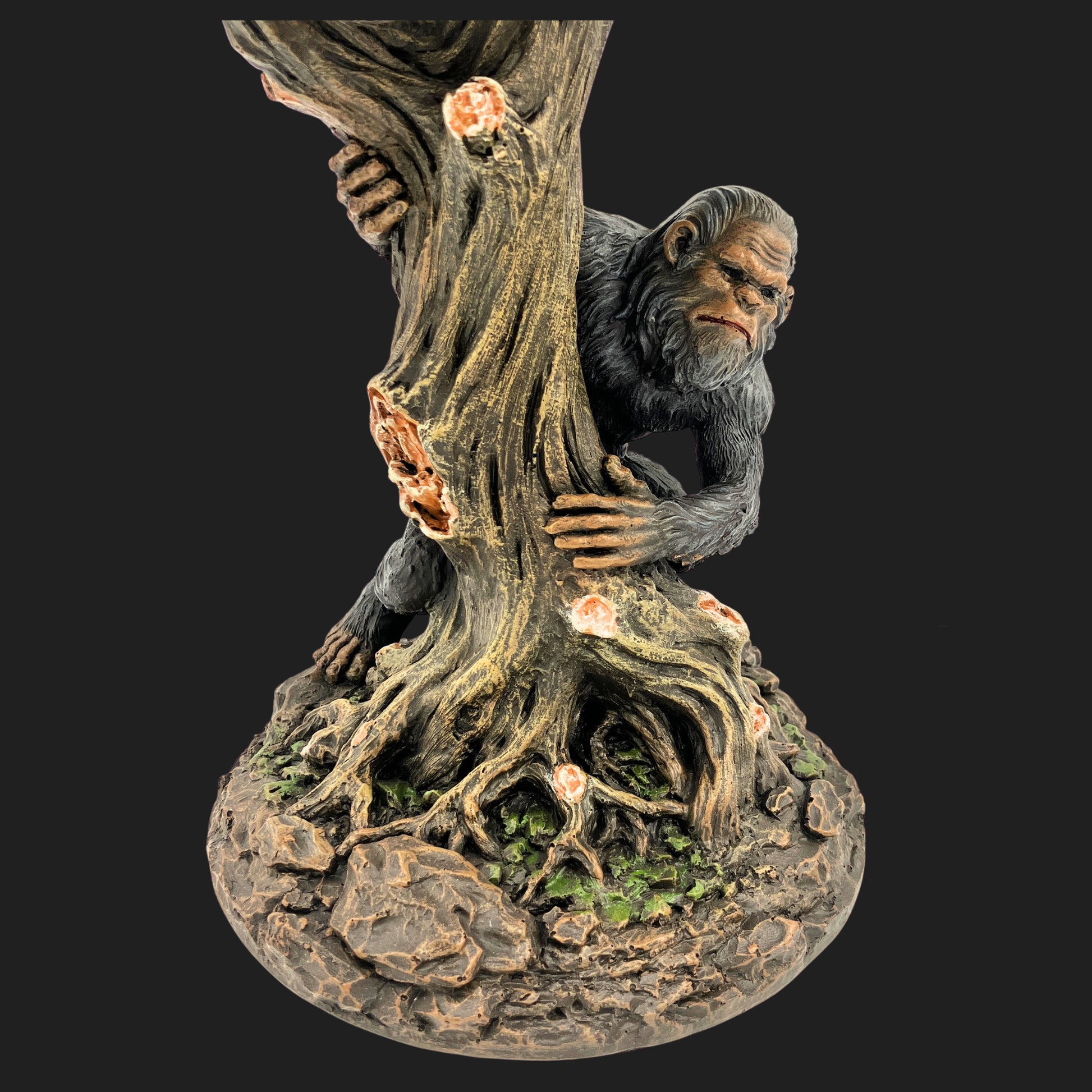 Close-up of sculpted Bigfoot figure gripping a tree on a forest base lamp