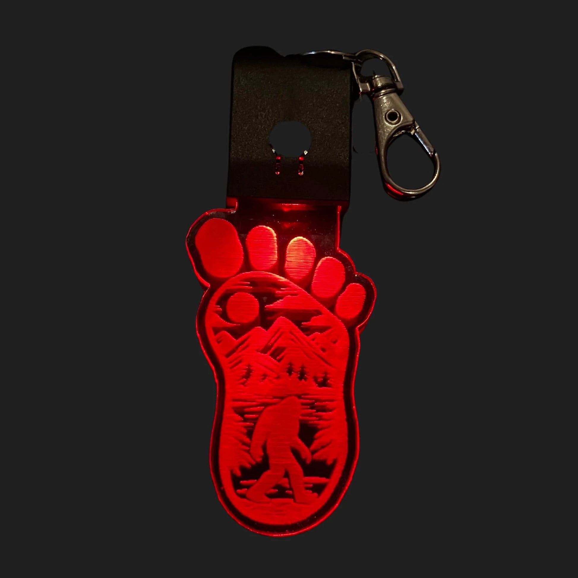Bigfoot footprint LED charm glowing red with etched Sasquatch design