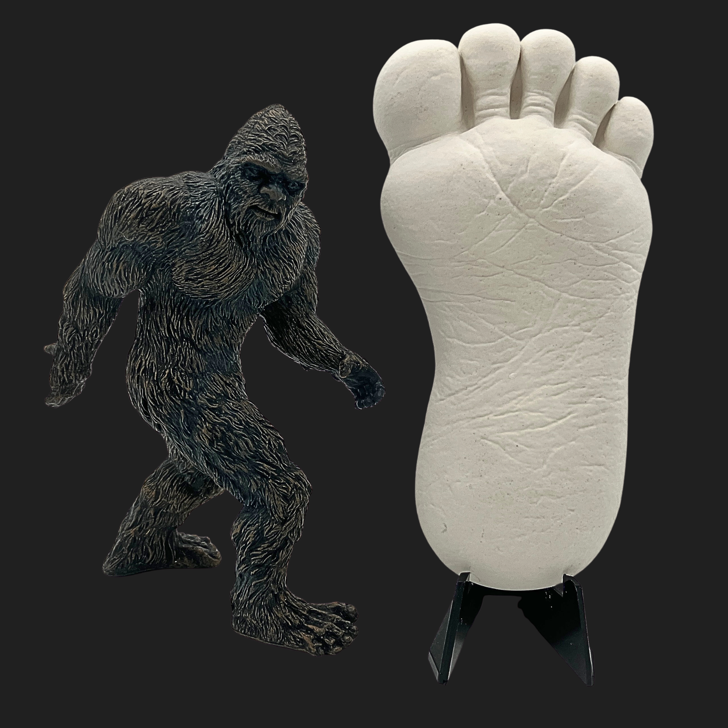 Bigfoot mini cast footprint replica with Bigfoot figure for size and visual comparison on dark background