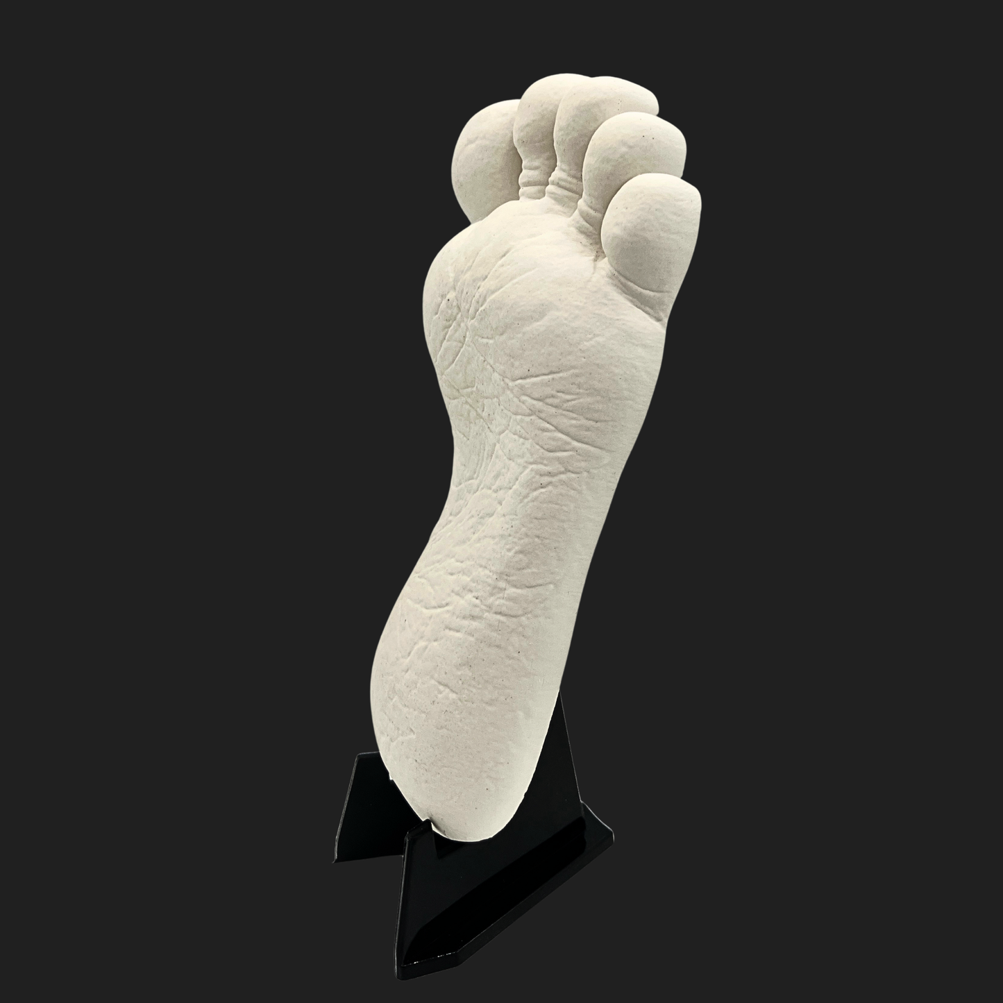 Bigfoot mini cast footprint side angle view on display stand against dark background by Lair of Mythics