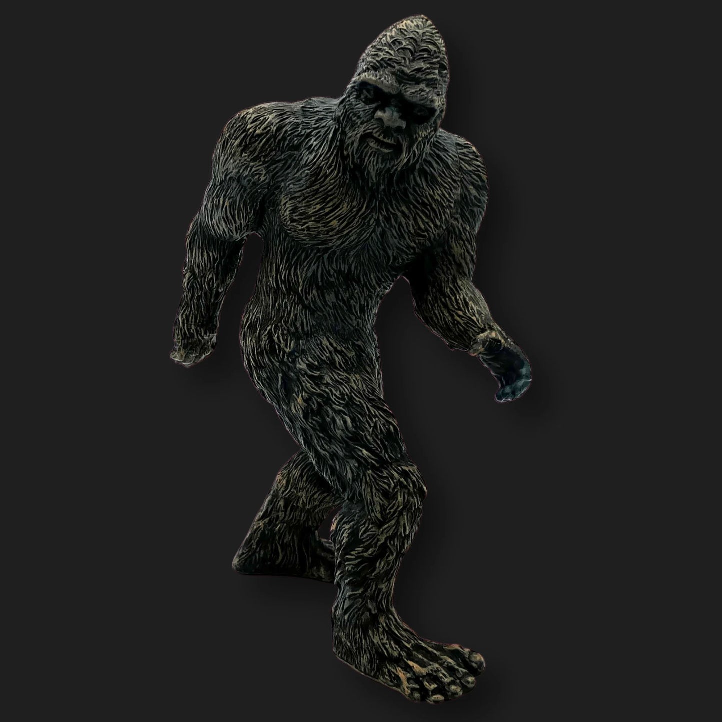 Dark Bigfoot figurine in a walking pose with detailed fur texture, front angle.