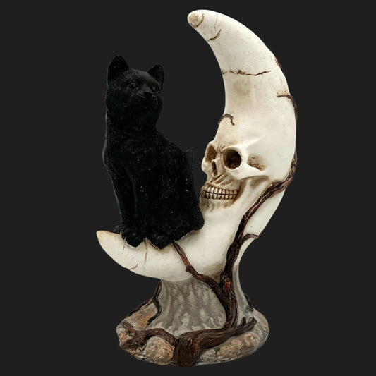 Gothic statue of black cat perched on crescent moon entwined with skull and tree roots