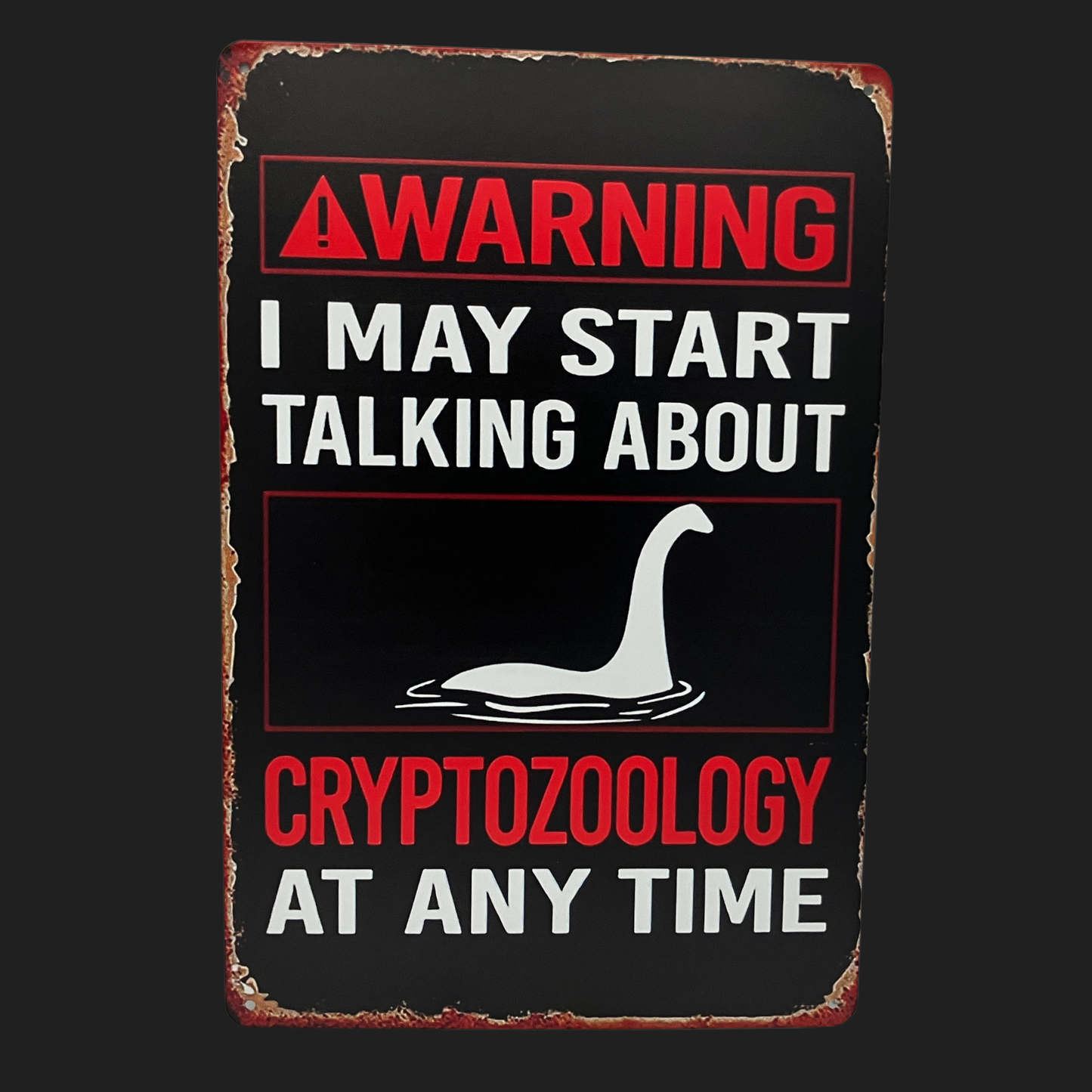 Vintage-style metal sign reading “Warning: I May Start Talking About Cryptozoology,” featuring Loch Ness Monster graphic, from Lair of Mythics.