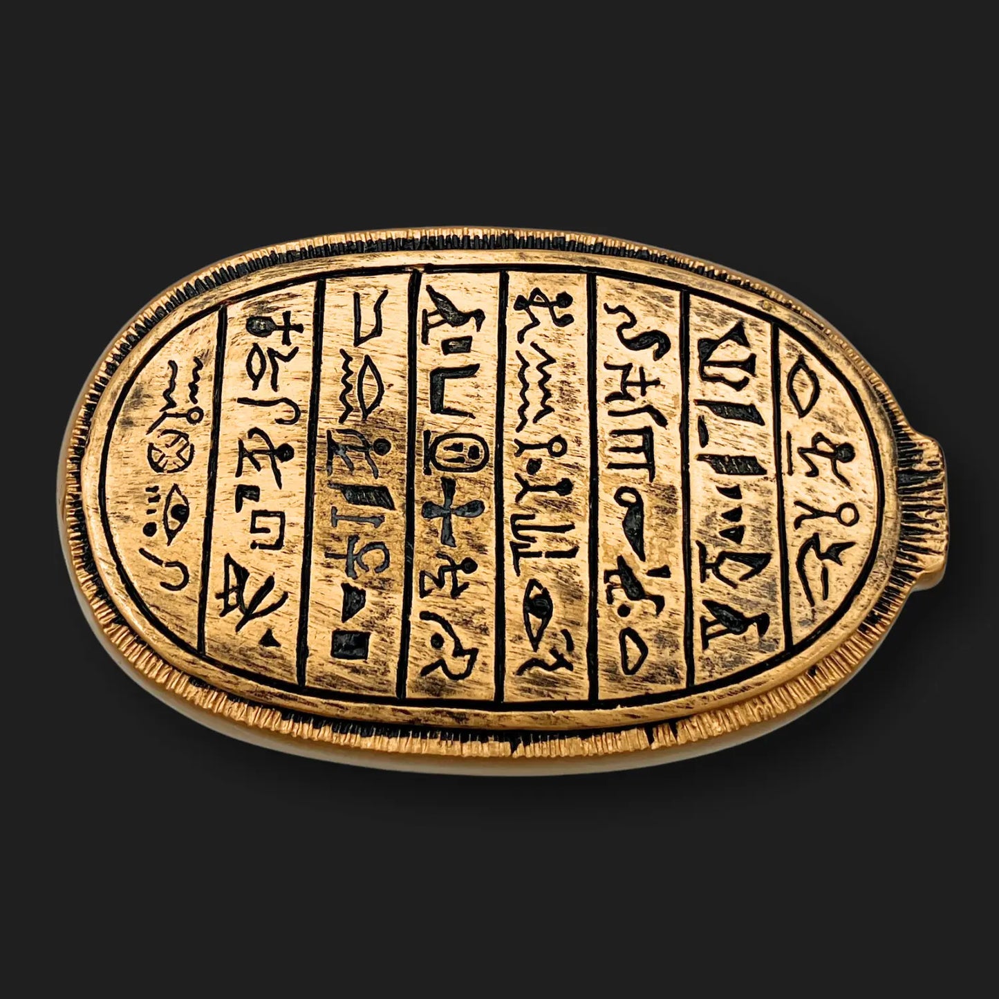 Underside of 4” x 2.5” emerald scarab relic showing engraved hieroglyphics.