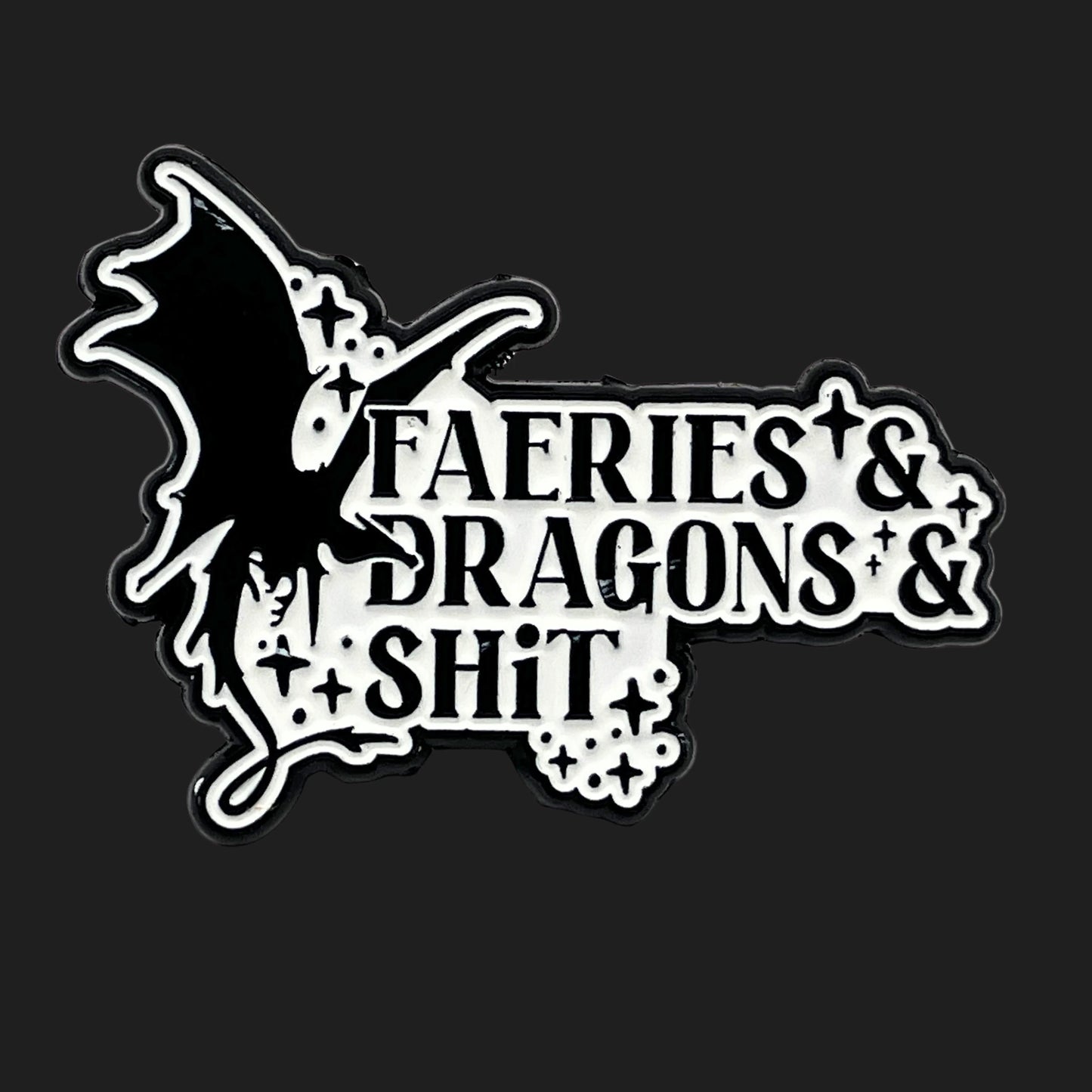 Black and white enamel pin with a dragon silhouette and the phrase “Faeries & Dragons & Shit.”