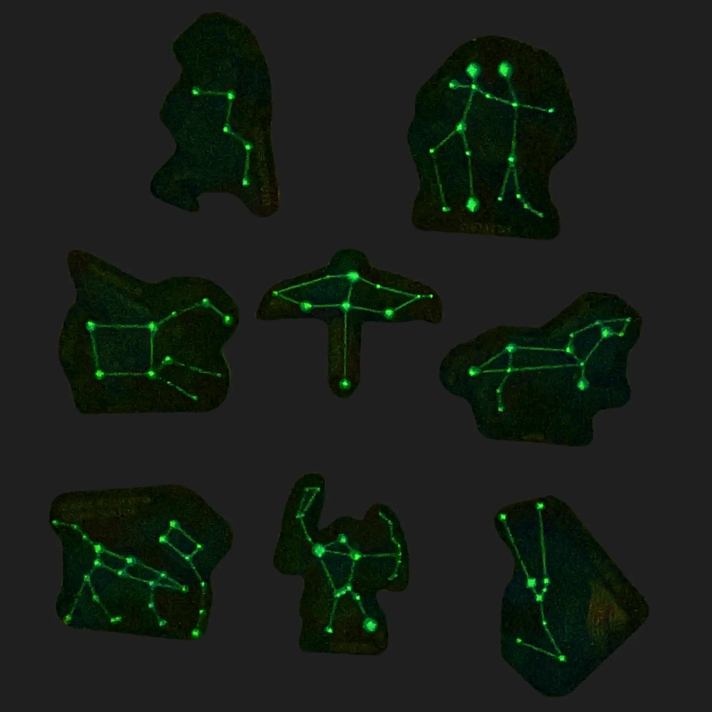 Glow-in-the-dark constellation magnets showing Orion, Leo, and more under dark light
