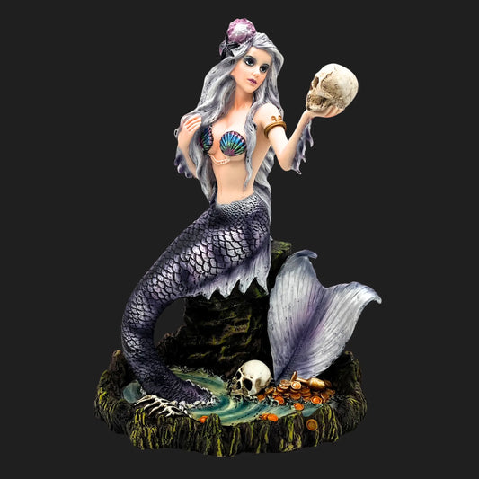 Gothic mermaid figurine with silver hair and purple scales, holding a skull above a treasure hoard