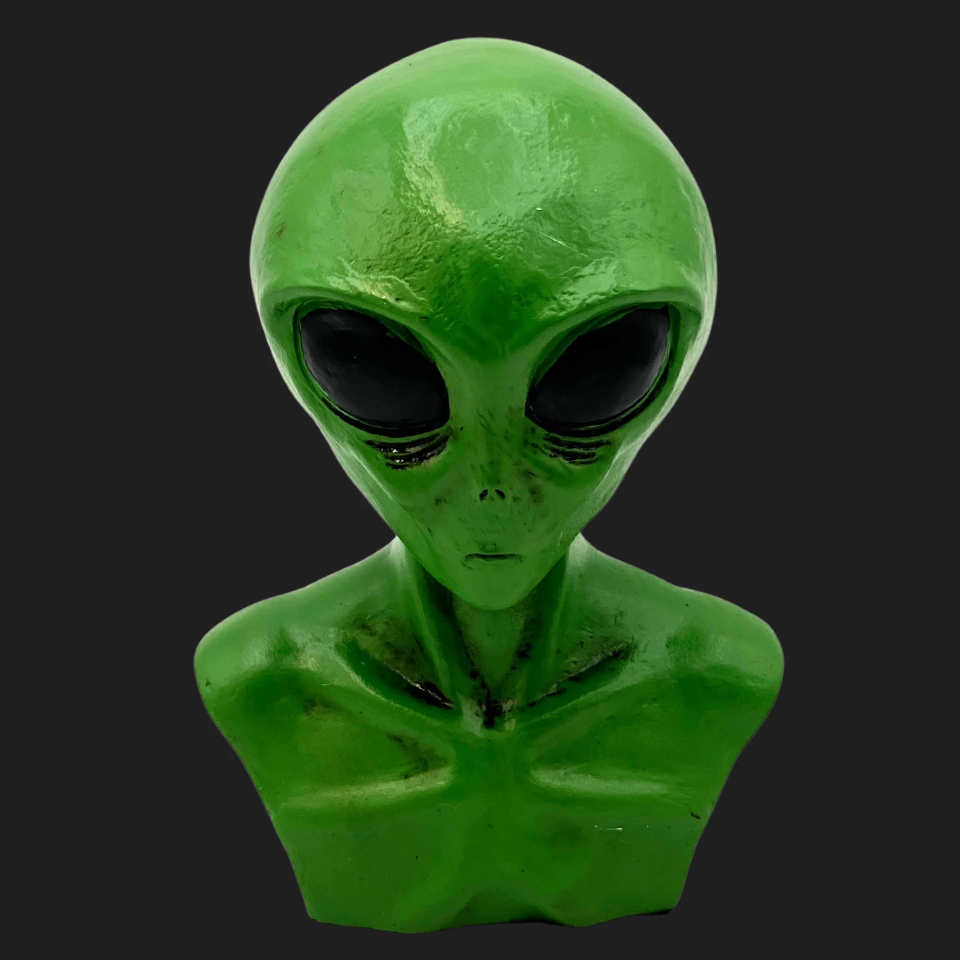 Front view of green alien bust with large black eyes and humanoid chest details