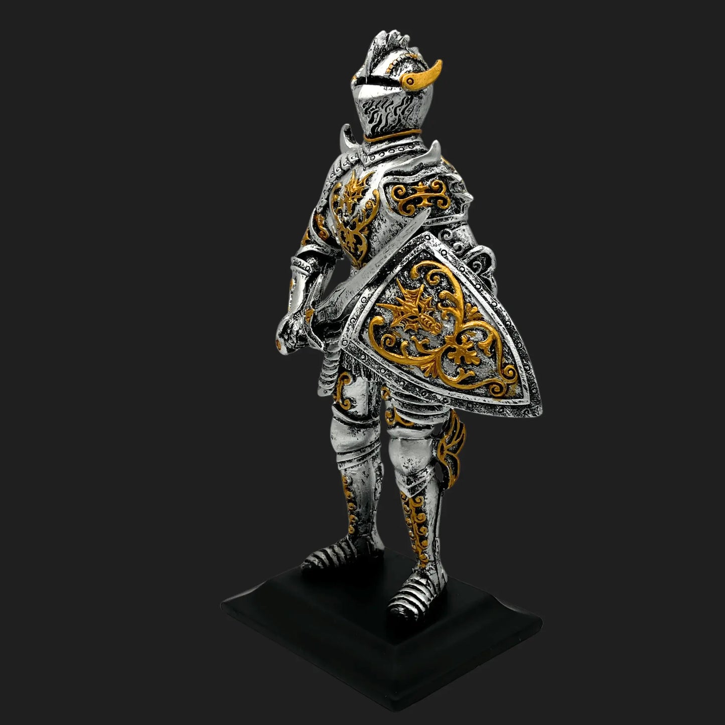 Knight of the Dragon Order statue in silver and gold armor holding ornate shield and sword, angled view
