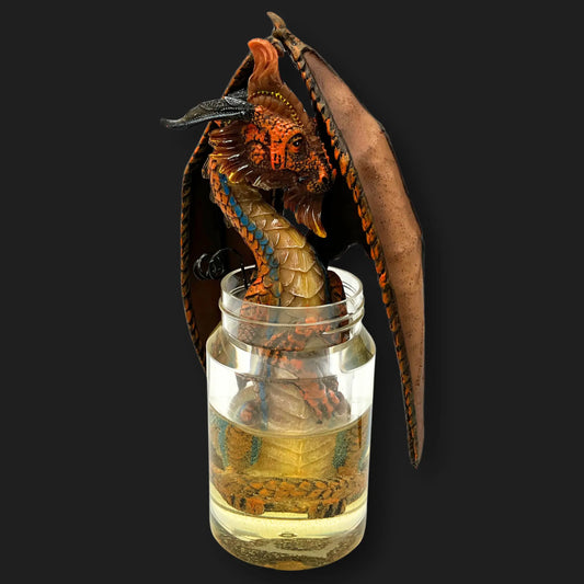 Front view of the moonshine dragon statue in jar with fiery orange scales fantasy décor.