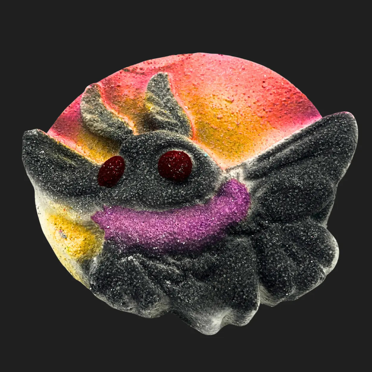 Mothman bath bomb with red glowing eyes, black wings, and a sunset background