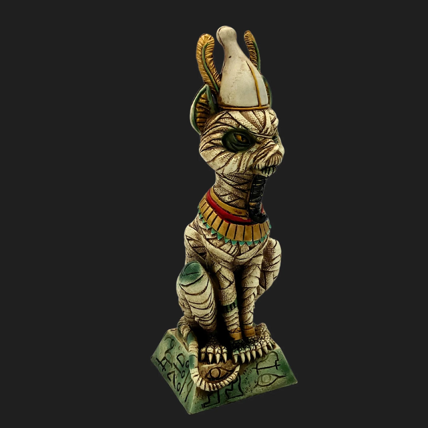 Front view of mummified Egyptian cat Osiris statue with crown, green eyes, and ornate base marked with hieroglyphs — ancient guardian figurine.