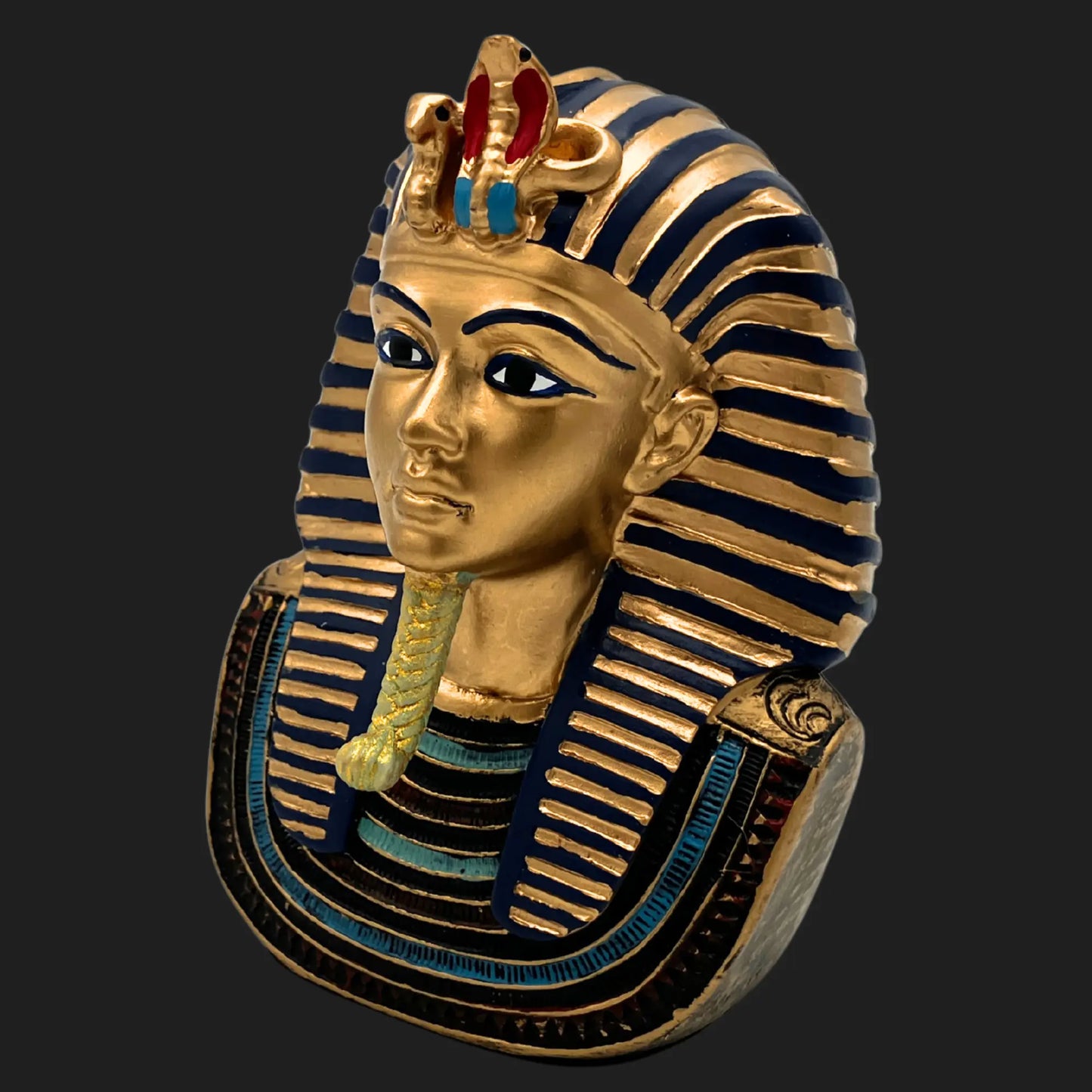 Side view of a golden Pharaoh Tutankhamun bust with striped nemes headdress and cobra ornament