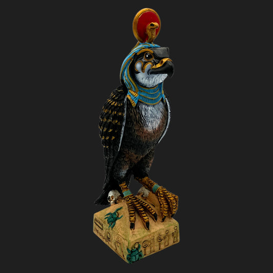 Front view of Ra falcon-headed Egyptian god statue with sun disk crown and ornate detailing — ancient deity figurine on carved base.