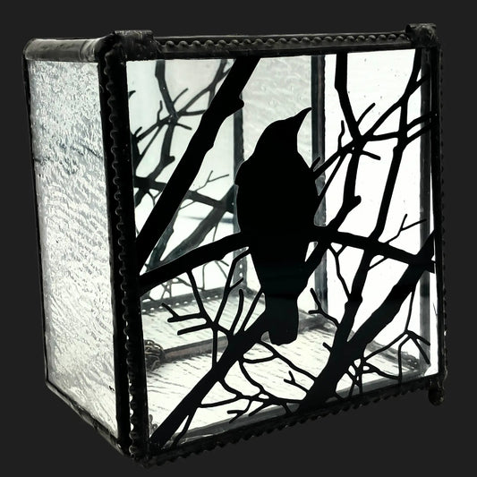 Side view of a raven art glass box with black silhouette design and mirrored base