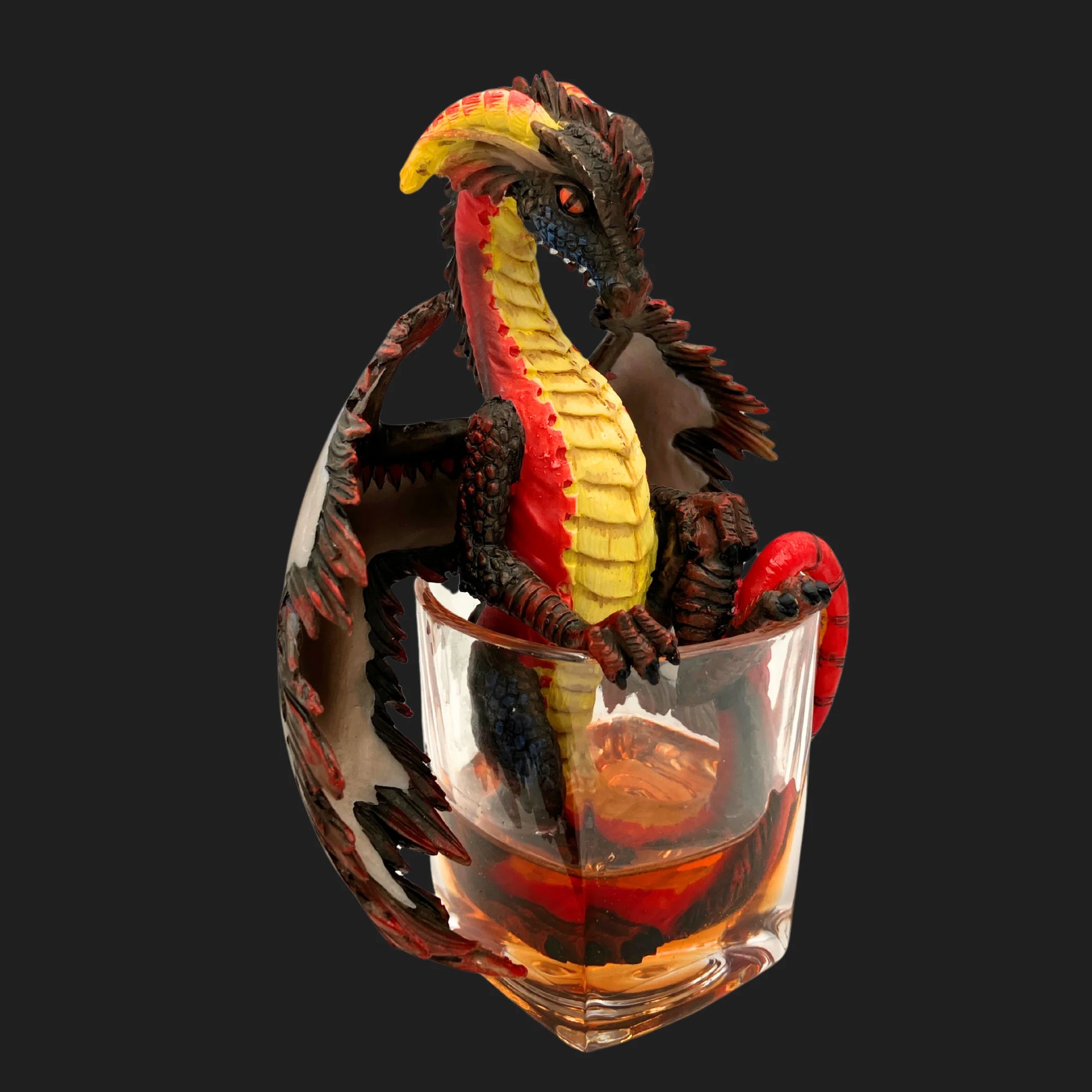 Side angle of rum dragon collectible in glass, red and gold fantasy décor.