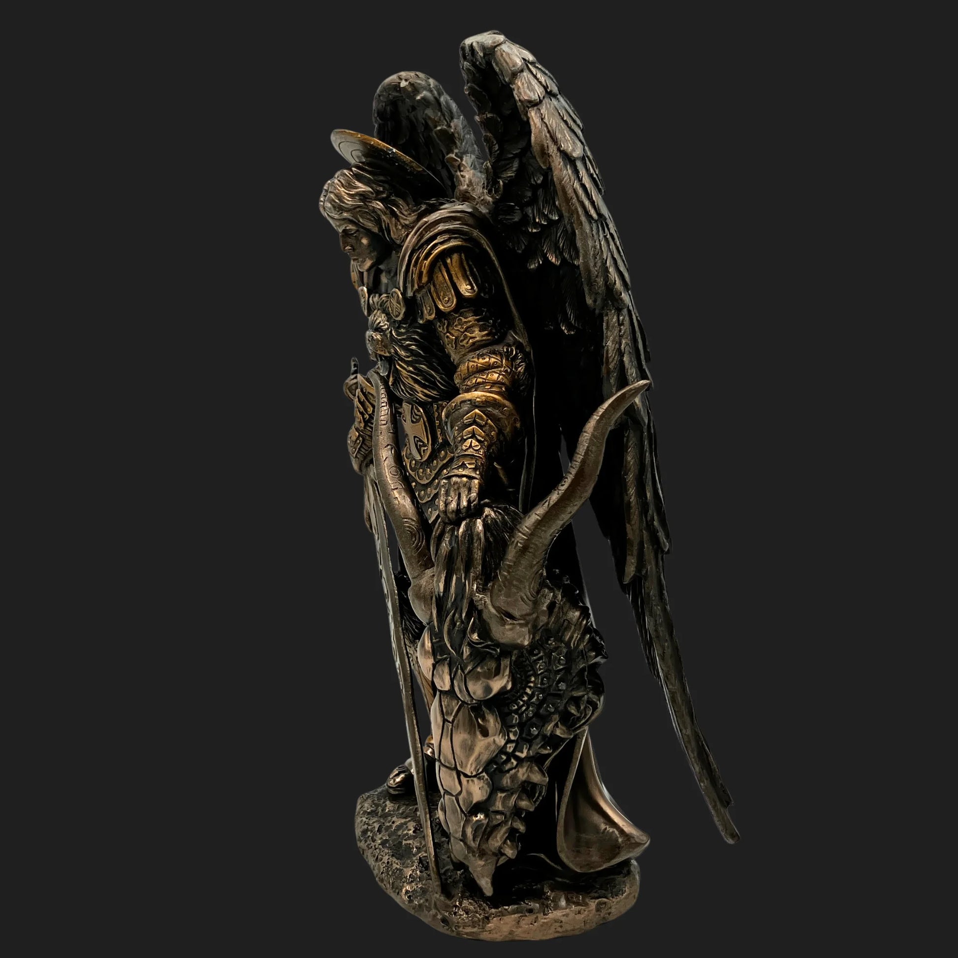 Side view of St. Michael Archangel figurine with wings and subdued demon