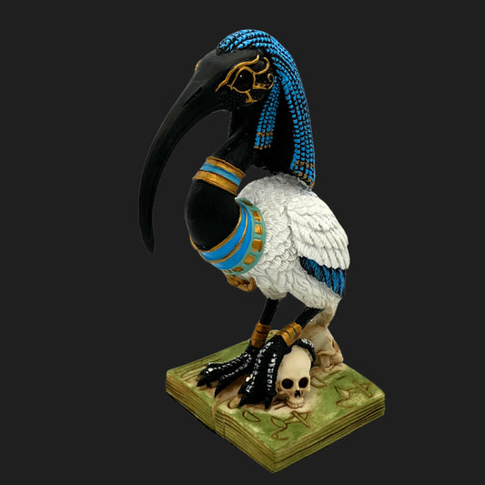 Egyptian god Thoth statue with black ibis head, braided headdress, and blue-gold ornaments — mythic deity figurine on hieroglyphic base