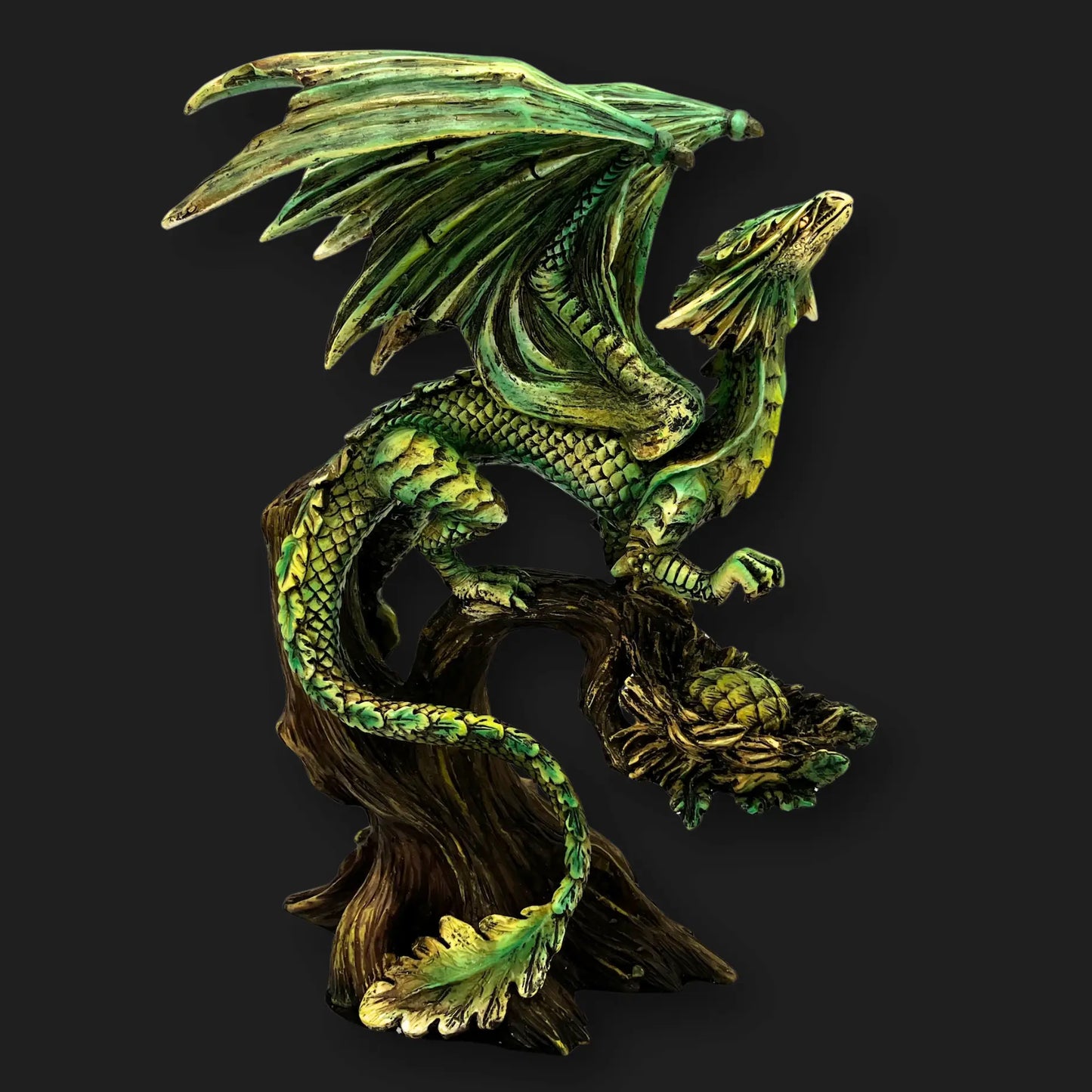 Side view of Tree Dragon Figurine with green scales and extended wings perched on tree