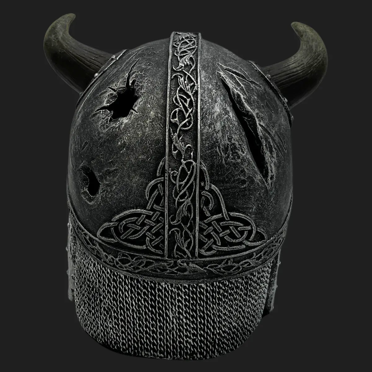 Back view of Viking skull helmet with carved Celtic knot designs and battle damage
