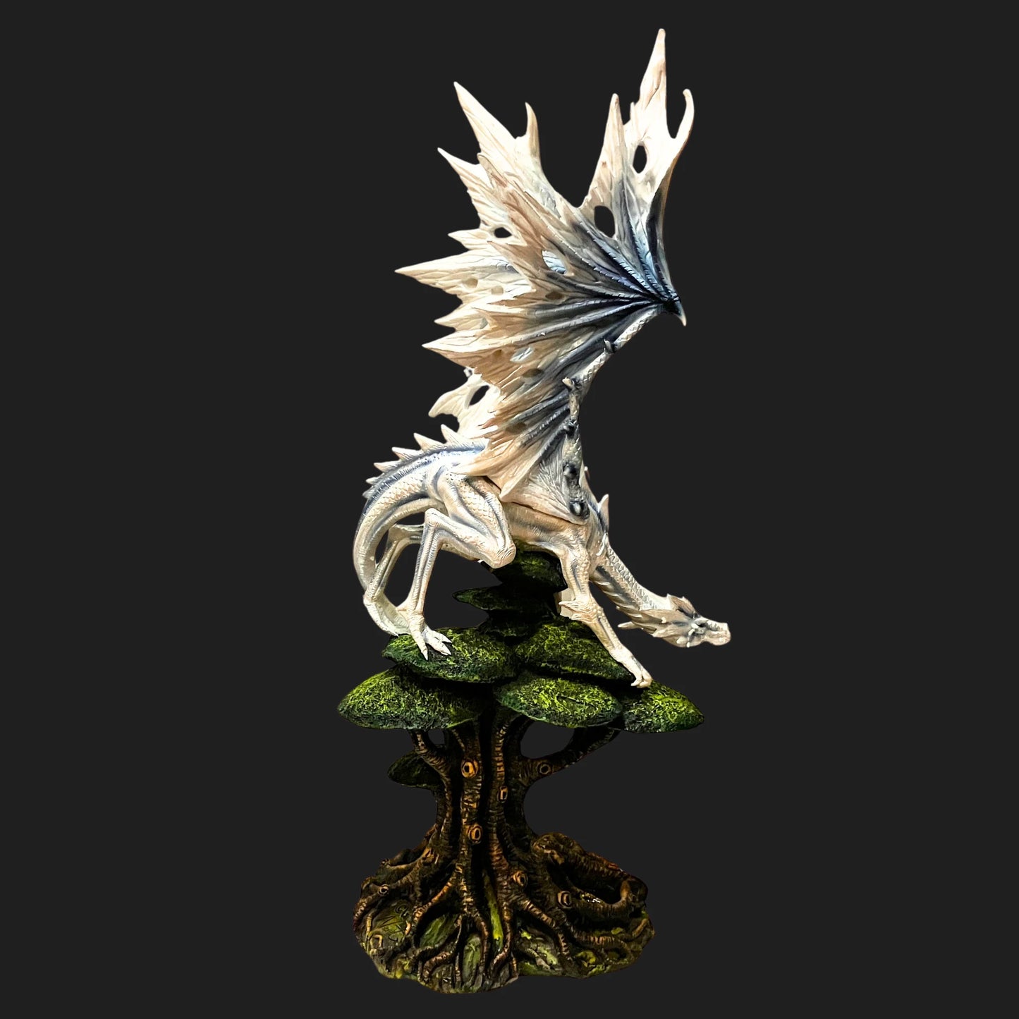 Back view of towering white dragon statue with expansive pearlescent wings.