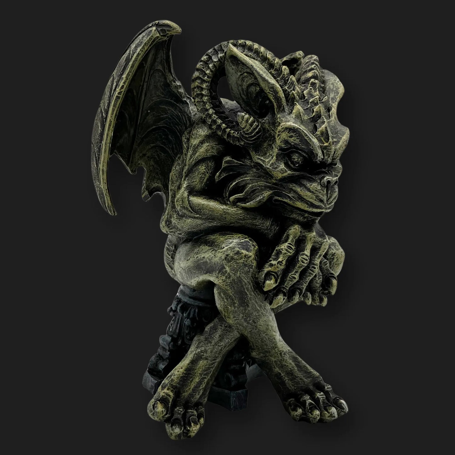 Angled view of gothic gargoyle figurine crouched with claws entwined