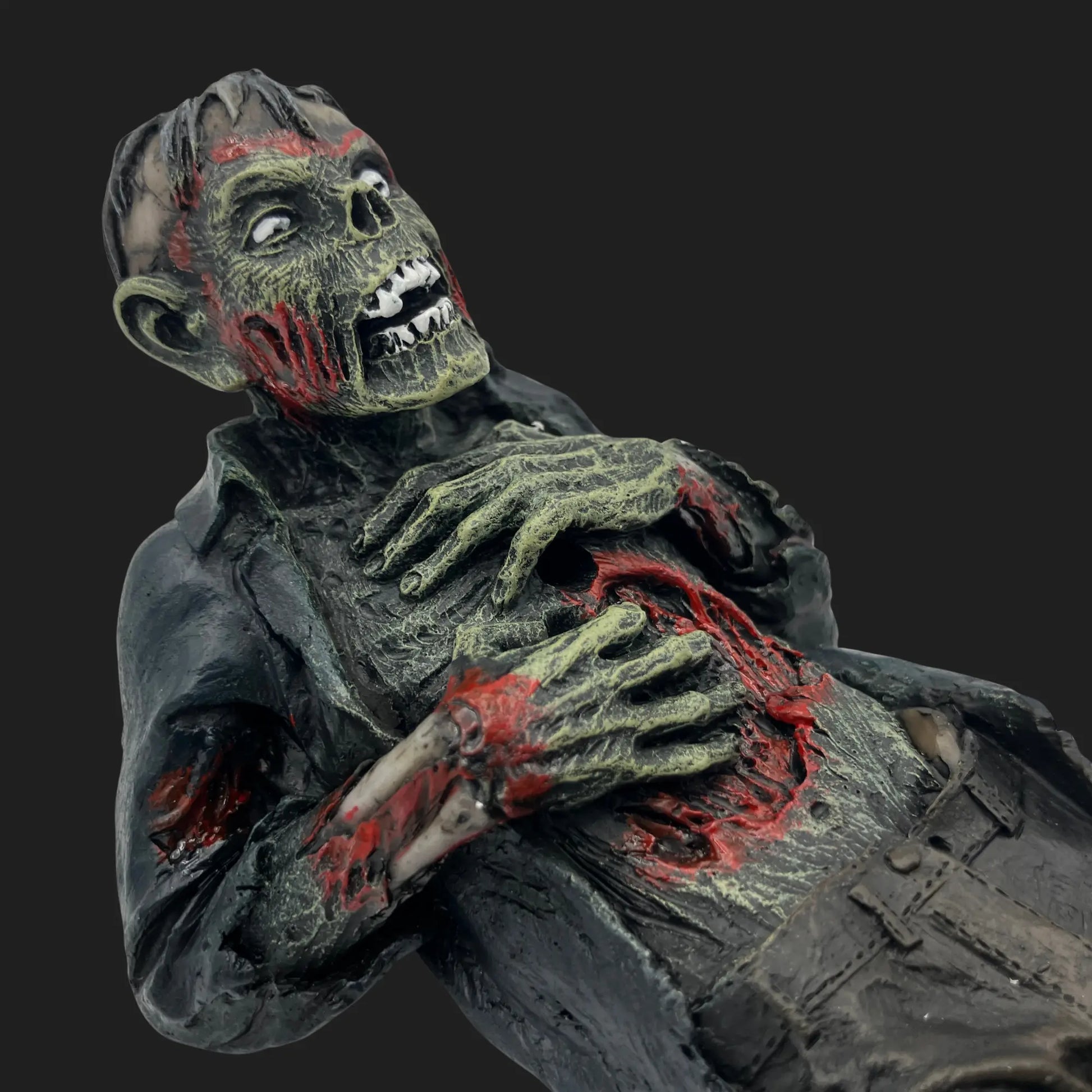 Angled view of zombie incense holder showing detailed wounds and decayed features