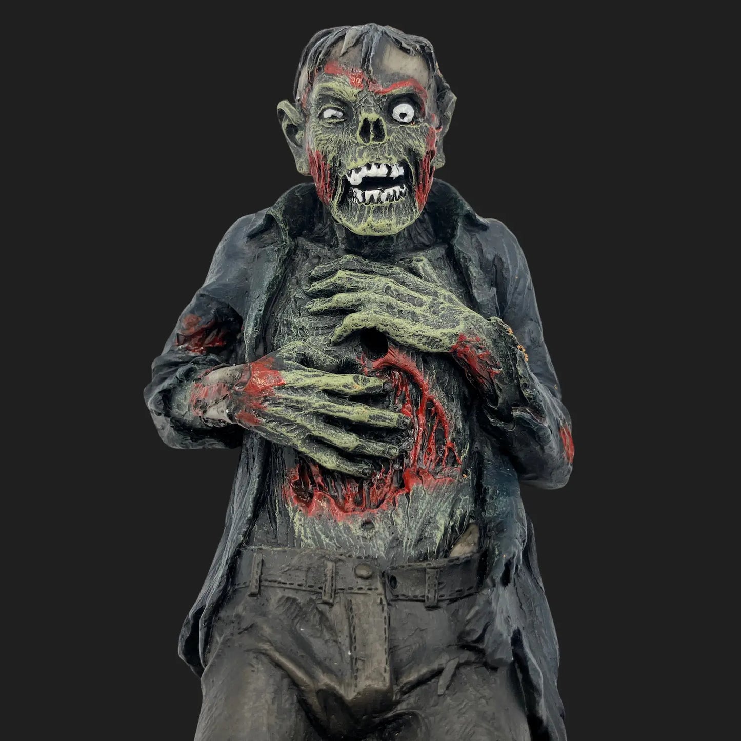 Front view of zombie incense holder figurine with rotting green skin and gaping wounds holding incense