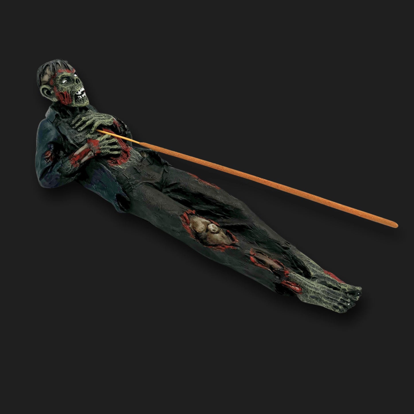 Zombie incense holder with incense stick placed through its chest, creepy horror décor piece