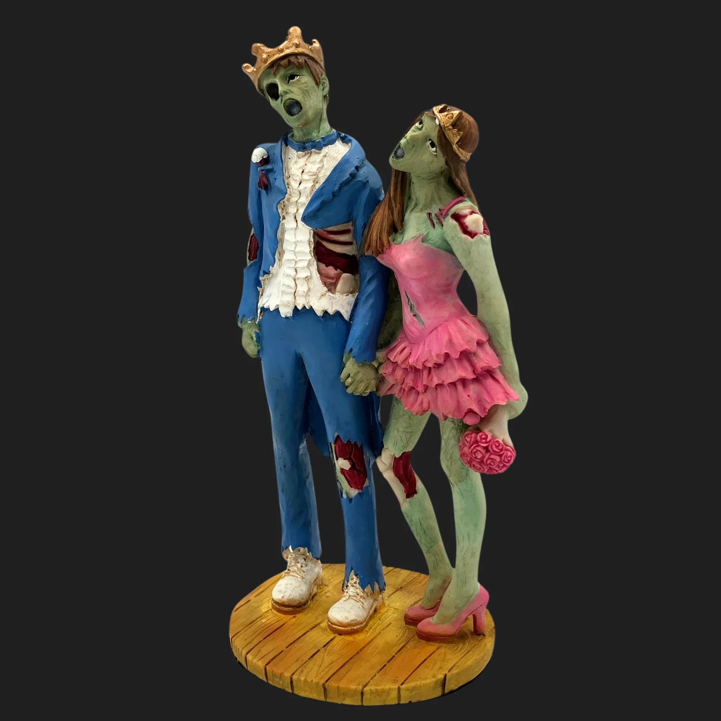Side view of Zombie Prom King in torn tux and Queen in pink dress, holding bouquet